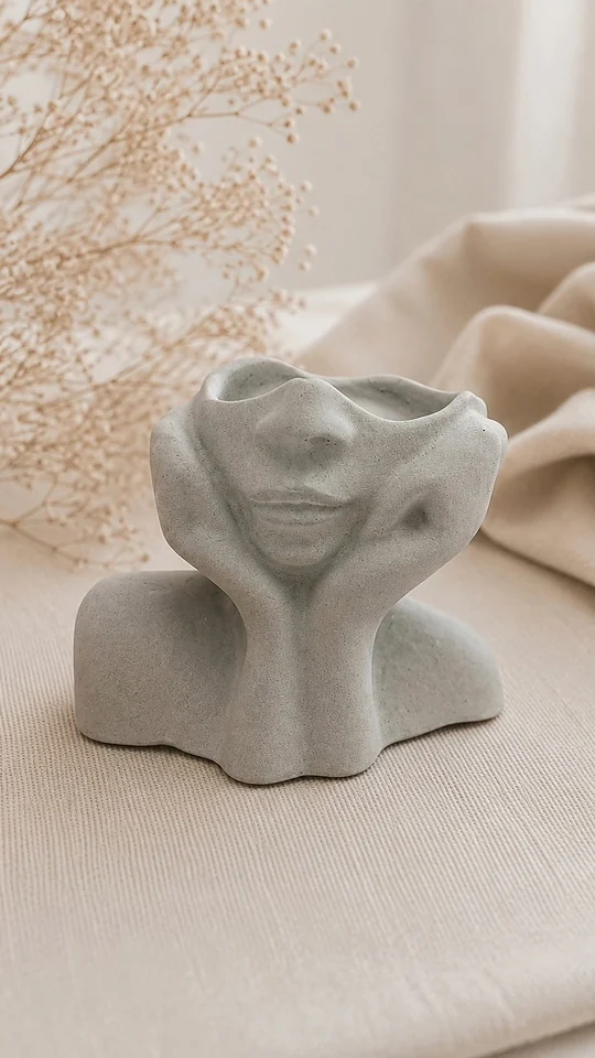 Vaso em forma de busto com rosto, sobre tecido de linho